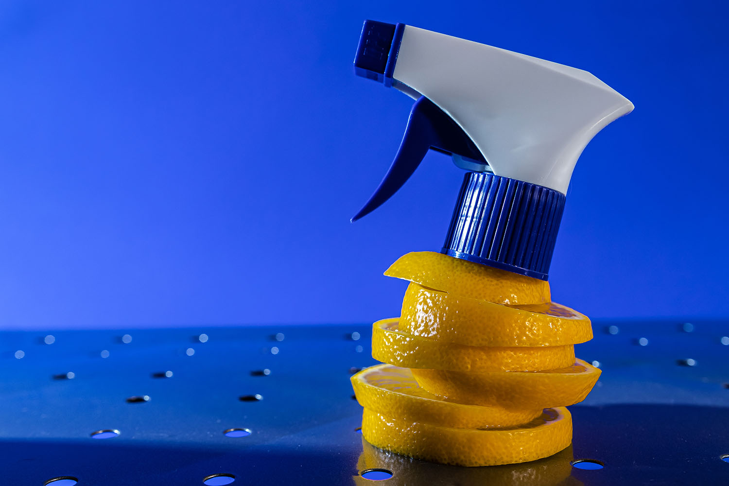 air freshener and window cleaner and lemon on a metal surface on a blue background