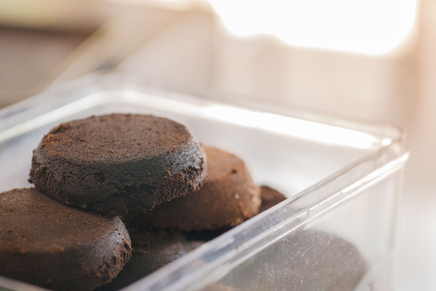 briquette used coffee grounds from espresso machine in plastic box, component of soap making for texture and aroma effect