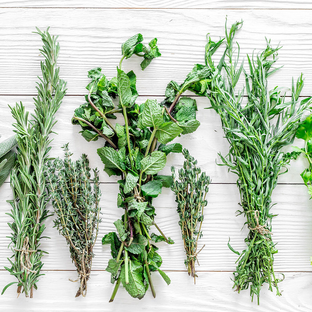 drying fresh herbs and greenery for spice food on white wooden kitchen desk background top view pattern